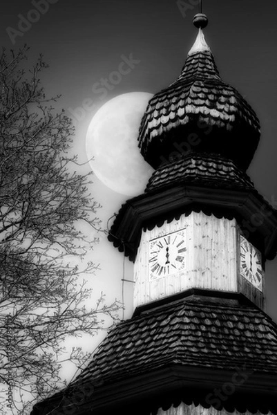 Obraz Church bell tower with old mechanical clock with only an hour hand at Midnight, with Full Moon on the sky. Monochrome, vertical view.