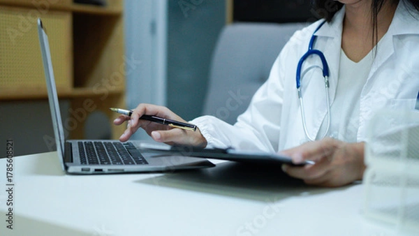 Fototapeta online medical consultation - doctor working on laptop computer in clinic office. copy space