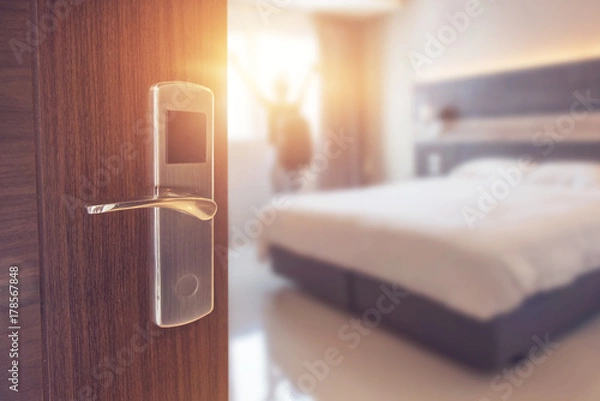 Obraz Rozpieczętowany drzwi pokój hotelowy w ranku z tłem zamazywał szczęśliwego backpacker podróżnika pobyt w hotelu, światło słoneczne skutek.