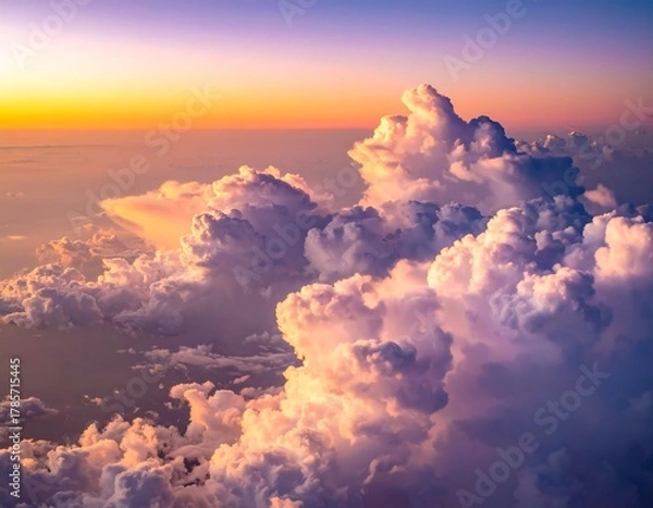 Fototapeta Aerial view showcases vibrant, sunlit clouds at dawn or dusk, with varying textures and colors