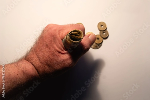 Obraz Hand gripping rolled japanese yen with coins