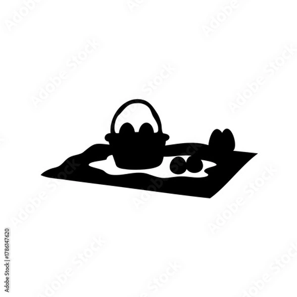 Fototapeta Silhouette of an Easter basket overflowing with eggs sitting on a blanket