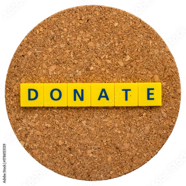 Fototapeta "DONATE" written in letter blocks on a cork board