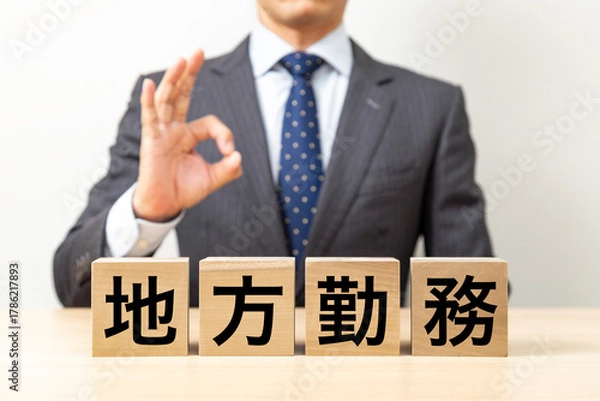 Fototapeta 「地方勤務」と書かれたブロックとOKポーズをするビジネスマン