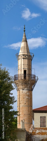 Fototapeta Historic minaret tower against blue sky in Crete