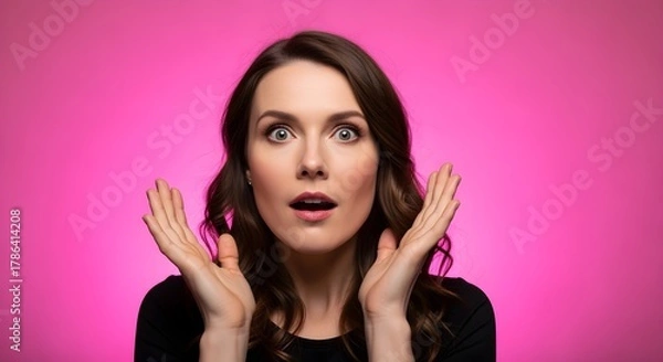Fototapeta Surprised Woman with Wide Eyes and Open Mouth on a Vibrant Pink Background