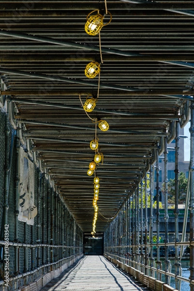 Obraz Lighting in protective scaffolding for pedestrian walkway