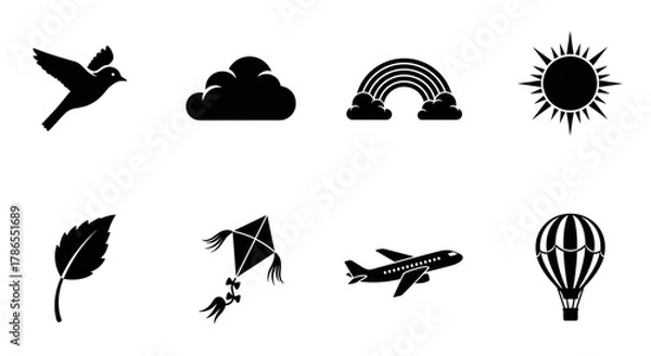 Fototapeta Black silhouette icons of a bird, cloud, rainbow, sun, leaf, kite, airplane, and hot air balloon, representing various elements of nature and travel.