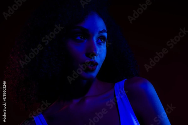 Fototapeta Portrait of a Young Woman in Neon Blue and Red Lighting Showcasing Beauty, Style, and Contemporary Art in a Studio