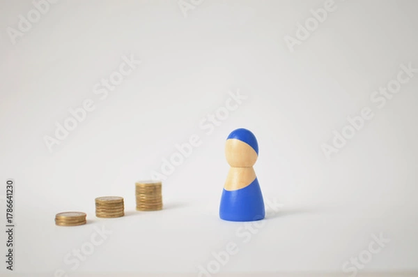 Obraz Financial growth concept with wooden figure and stacked coins