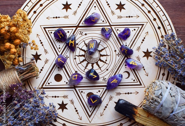 Obraz Rose quartz crystals and Scandinavian runes made from natural amethyst, along with dried lavender herbs, on a wooden altar for divination. Divination, witchcraft, and spiritual esoteric practice.