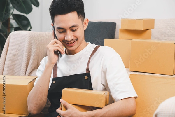 Fototapeta Startup small business owner packing boxes for online customer delivery. Entrepreneur managing e-commerce orders, shipping parcels, and running home-based business operations from home office.
