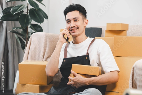 Fototapeta Startup small business owner packing boxes for online customer delivery. Entrepreneur managing e-commerce orders, shipping parcels, and running home-based business operations from home office.