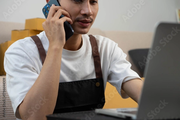 Fototapeta Startup small business owner packing boxes for online customer delivery. Entrepreneur managing e-commerce orders, shipping parcels, and running home-based business operations from home office.