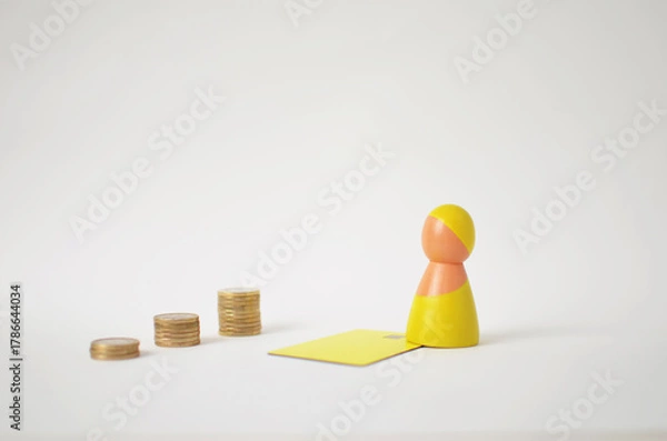 Obraz Wooden pawn and credit card symbolizing financial progress with growing coin stacks