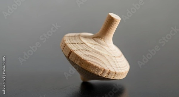 Fototapeta Minimalist wooden spinning top on a reflective surface for creative uses