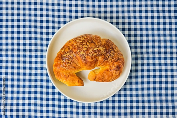 Fototapeta Top view of one cheese croissant on white plate. close up. isolated on the napkin background. High angle, above, flat lay.