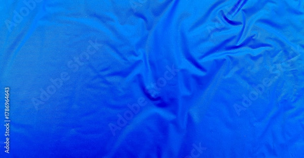 Obraz Smooth blue waterproof fabric with light wrinkles and soft reflections, ideal for background, design mockups, or outdoor gear material texture close-up.