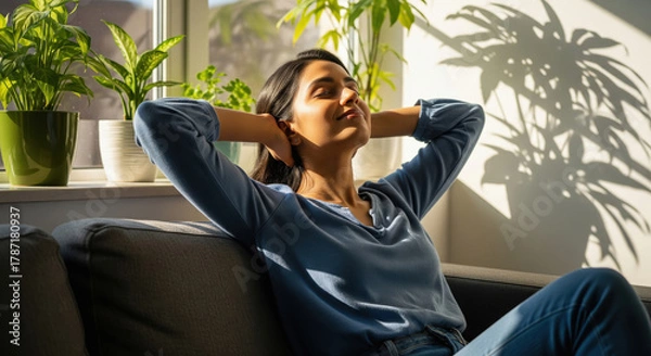 Fototapeta Blissful woman relaxing on sofa, enjoying sun and home comfort.