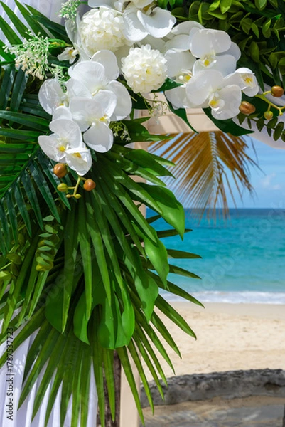 Obraz Bathed in sunlight, the wedding pagoda blooms with white orchids and silk, overlooking the turquoise Caribbean Sea