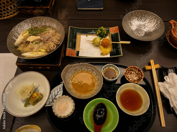 Obraz Japanese ryokan kaiseki dinner main dish including pork shabu hot pot, variety of vegetables, with salt and sesame vinegar sauce, side dishes and fried food of spring