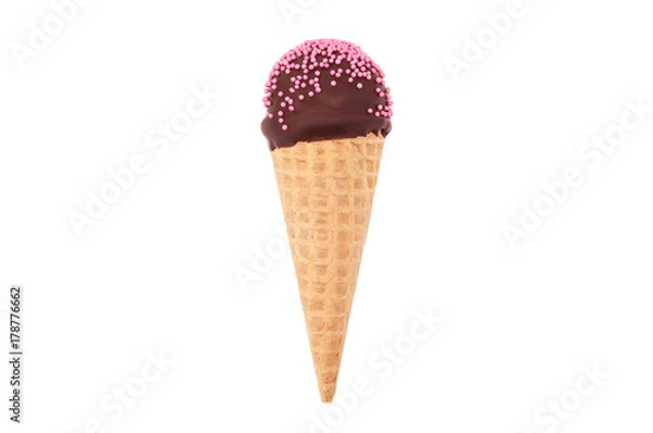 Fototapeta Chocolate cake pop in waffle cone for ice cream, decorated with pink confectionery sprinkles. Isolated. Picture for a menu or a confectionery catalog.