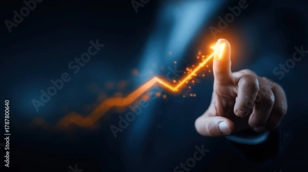 Fototapeta A business professional in a dark suit points at an upward trend line glowing in orange. The setting suggests a focus on growth and success in finance or analytics
