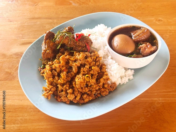 Fototapeta Thai-style meal featuring various traditional dishes served over rice