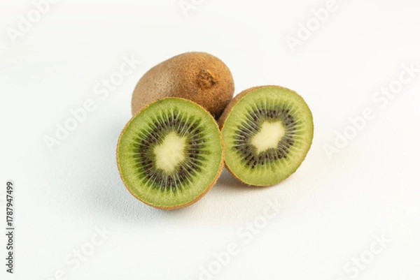 Fototapeta brown sour kiwis sliced lined isolated on the white desk