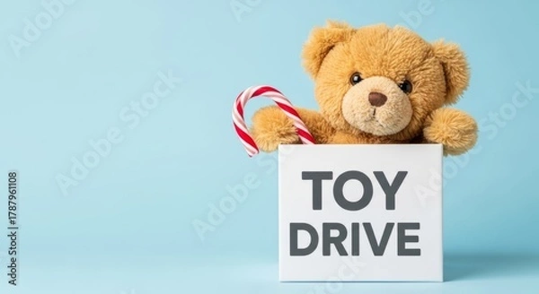 Obraz Cute brown teddy bear holding a candy cane peeking over a toy drive sign promoting charitable giving