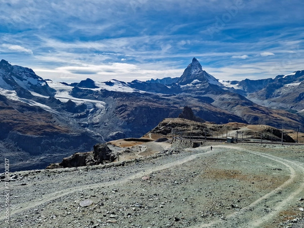 Obraz Scenic view from Gornergrat mountain towards the iconic Matterhorn peak in Switzerland. The cogwheel railway from Zermatt winds through the autumn alpine landscape.