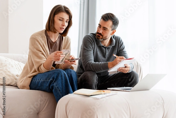 Fototapeta Couple managing home budget calculating finances and expenses