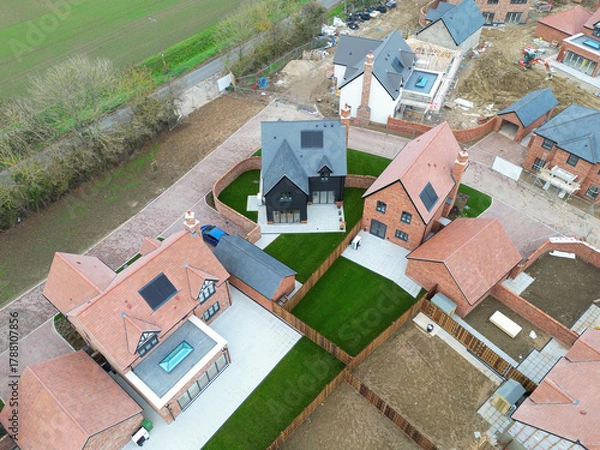 Fototapeta Drone top down view of recently built expensive detached family homes. A large conservatory and glass lantern is seen on the left.