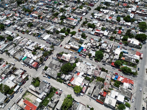 Fototapeta Aerial top-down view high altitude of slum a heavily populated urban informal settlement characterized by substandard housing and squalor poor living conditions streets and rusty metal home roof tops