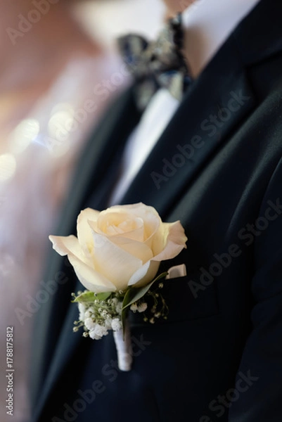 Fototapeta butonierka z białej róży przypięta do marynarki pana młodego