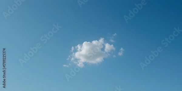 Obraz Single Fluffy Cloud Floating in a Brilliant Blue Sky