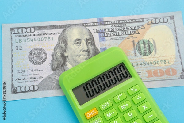 Obraz Business concept with dollar banknote and calculator on light blue background
