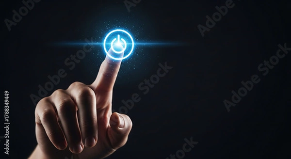 Fototapeta Close-up of a person's index finger touching a glowing blue digital power button on a dark background.