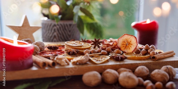 Fototapeta Dried citrus fruits and apple rings with nuts on rustic wood. Background for christmas preparations and decorations.