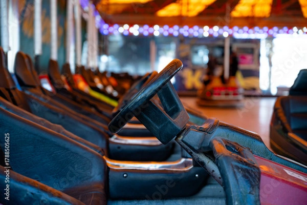 Fototapeta Colorful electric bumper cars parked on an amusement park arena.