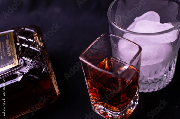 Fototapeta Top side view of liquor in a cup and brown liquor in a bottle. The frame also has a cup of ice in a cocktail glass. 
