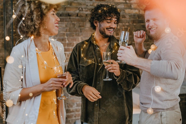 Fototapeta A group of friends dancing with raising glasses of champagne on the Happy New Year party