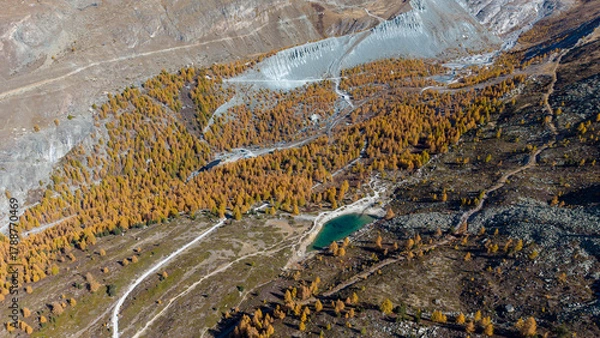 Fototapeta A drone view above Zermatt reveals the stunning Matterhorn region with its famous lakes, golden larches, and a deep blue autumn sky in perfect harmony.
