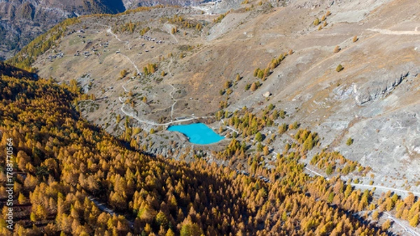 Fototapeta A drone view above Zermatt reveals the stunning Matterhorn region with its famous lakes, golden larches, and a deep blue autumn sky in perfect harmony.