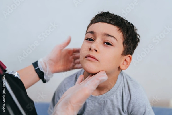 Obraz The healthcare worker carefully examines the boy’s face, fostering a sense of calm and trust during a health check.