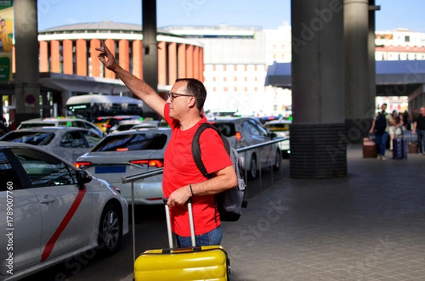 Obraz Man hailing taxi for urban travel at station