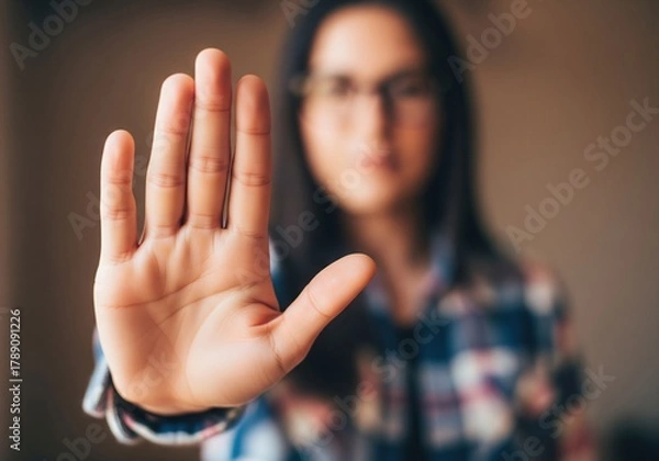 Obraz Determined woman holding hand up in stop gesture, conveying firm boundaries and personal safety