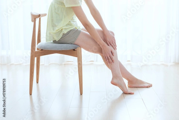 Obraz リビングでフットマッサージをする女性