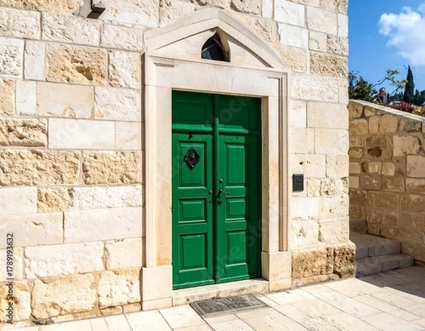 Fototapeta Close-up of a weathered stone building entrance with a vibrant green door