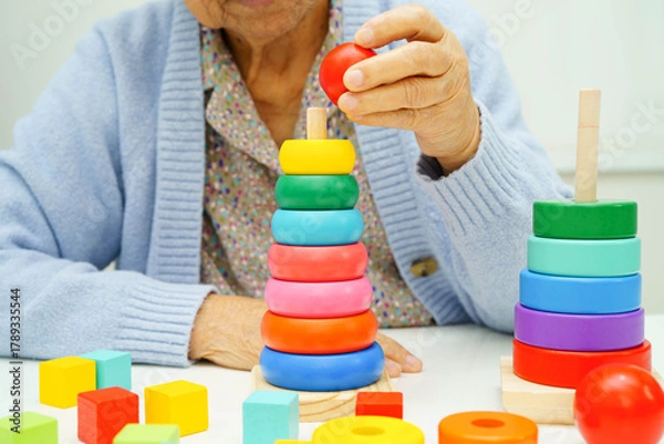 Fototapeta Asian elderly woman playing enhancing skill board game.